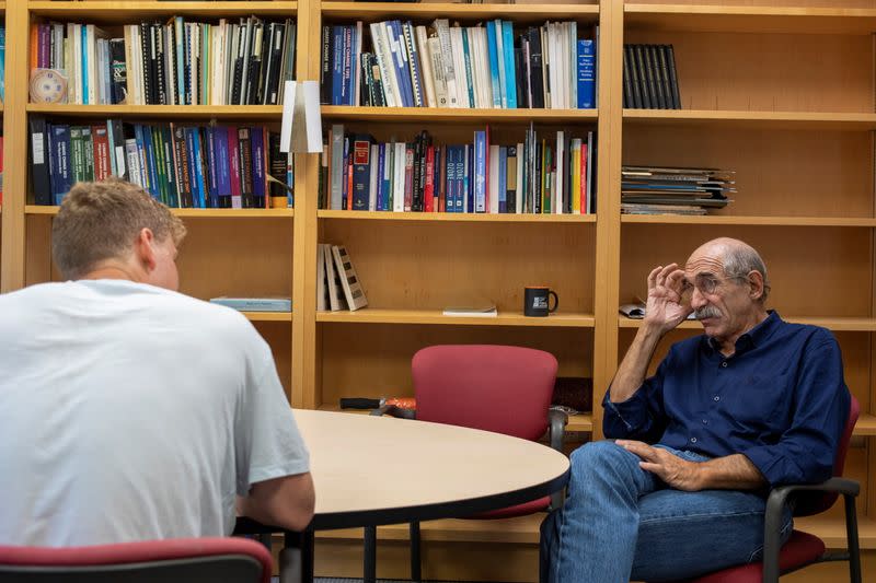 Michael Oppenheimer speaks with a student in his office at Princeton University