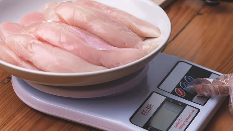 digital scales weighing raw chicken