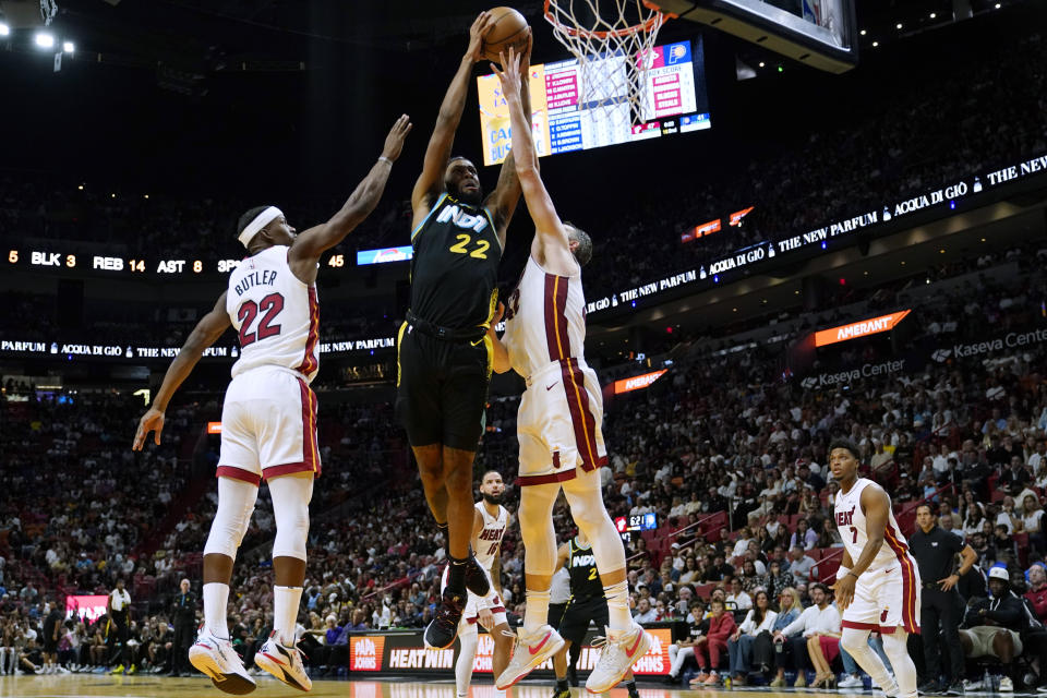 Indiana Pacers forward Isaiah Jackson (22) goes to the basket as Miami Heat forward Jimmy Butler (22) and forward Kevin Love, right, defend during the first half of an NBA basketball game Saturday, Dec. 2, 2023, in Miami. (AP Photo/Lynne Sladky)