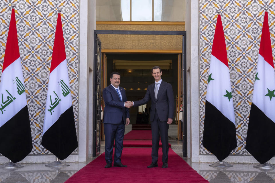 In this photo released by the Syrian official news agency SANA, Syrian President Bashar Assad, right, welcomes Iraq's Prime Minister Mohammed Shia al-Sudani during a welcome ceremony in Damascus, Syria, Sunday, July 16, 2023. Iraq's prime minister held talks Sunday with Syrian President Bashar Assad in Damascus during the first such trip by an Iraqi premier to the war-torn country since the 12-year conflict began. (SANA via AP)