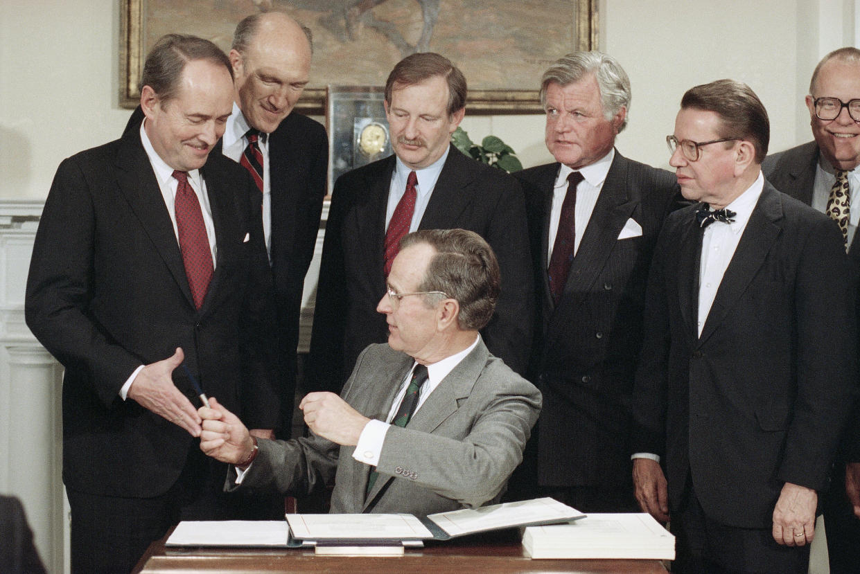 FILE - President George H. Bush hands a pen to Attorney General Dick Thornburgh, left, after he signed into law an immigration bill, Nov. 29, 1990, in Washington at the White House. From left often Thornburgh are Sen. Alan Simpson, R-Wyo., Rep. Bruce Morrison, D-Conn., Edward Kennedy, D-Mass., and Sen. Paul Simon, D-Ill. The last extensive package came under President Ronald Reagan in 1986, and President George H.W. Bush signed a more limited effort four years later. (AP Photo/Marcy Nighswander, File)