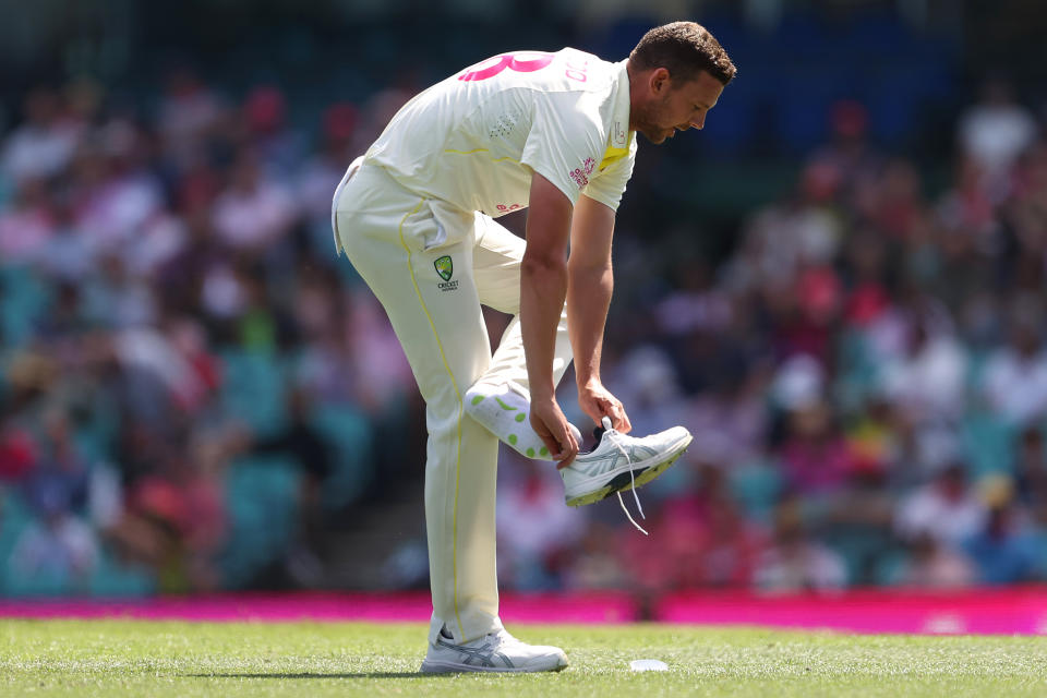 Josh Hazlewood fixes his shoe.