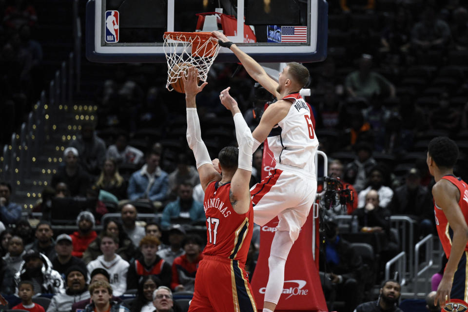 Washington Wizards center Kristaps Porzingis (6) dunks over New Orleans Pelicans center Jonas Valanciunas (17) during the first quarter of an NBA basketball game, Monday, Jan. 9, 2023, in Washington. (AP Photo/Terrance Williams)