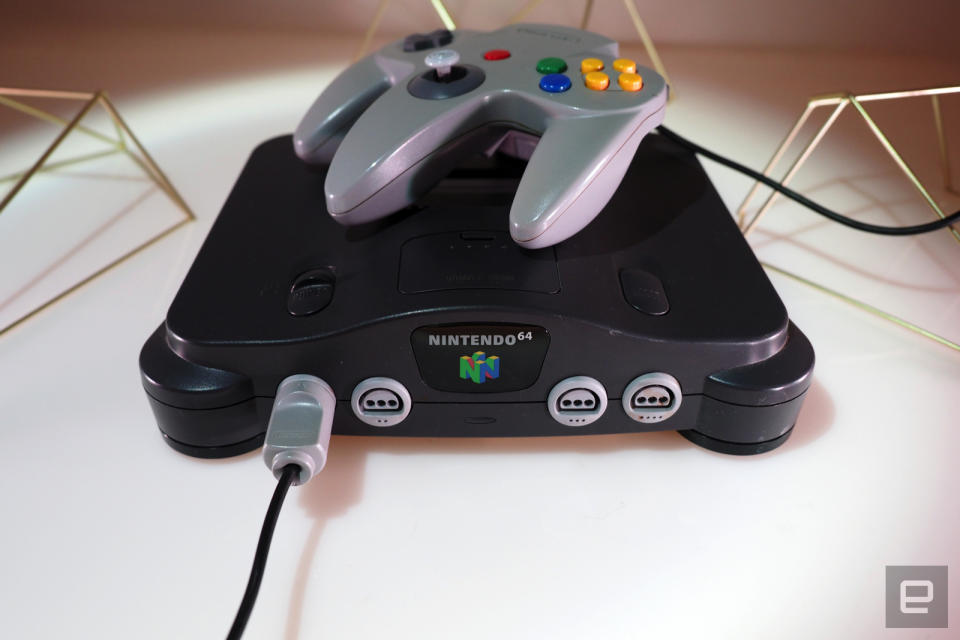 <p>Nintendo 64 on a white table with games</p>
