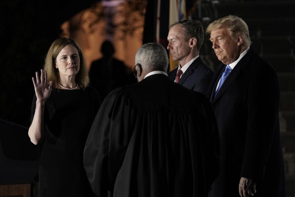 Supreme Court Justice Clarence Thomas administers the judicial oath to Amy Coney Barrett, as her husband Jesse Barrett and President Trump watch, during a ceremony at the White House, October 26, 2020. / Credit: Ken Cedeno/CNP/Bloomberg via Getty Images