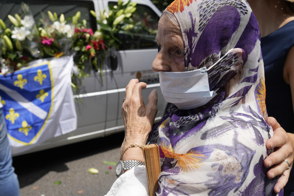 FILE - In this July 9, 2021, file photo, a woman looks at the motorcade transporting the remains of 19 victims of the Srebrenica massacre for reburial at a memorial cemetery in Srebrenica on Sunday, July 11. Twenty-six years after the July 1995 Srebrenica massacre, the only episode of Bosnia’s 1992-95 war to be legally defined as genocide, its survivors continue to grapple with the horrors they endured while also confronting increasingly aggressive downplaying and even denial of their ordeal. (AP Photo/Darko Bandic, File)