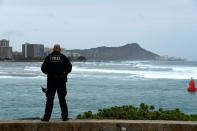 <p>Honolulu police officer Chad Asuncion monitors the water conditions and warns surfers about the conditions as Hurricane Lane approaches Honolulu, Hawaii, Aug. 23, 2018. (Photo: Hugh Gentry/Reuters) </p>