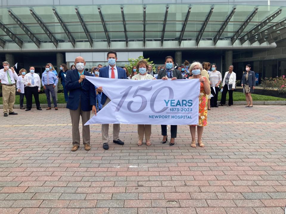Newport Hospital leadership and local officials display the 150th anniversary banner before flying it on the hospital’s flagpole.  Pictured left to rigth: Sen. Louis DiPalma; Dr. Jeffrey Gaines, senior vice president and chief medical officer, Newport Hospital; Orla Brandos, vice president and chief nursing officer, Newport Hospital; Crista Durand, president, Newport Hospital; Newport Mayor Jeanne Marie Napolitano.