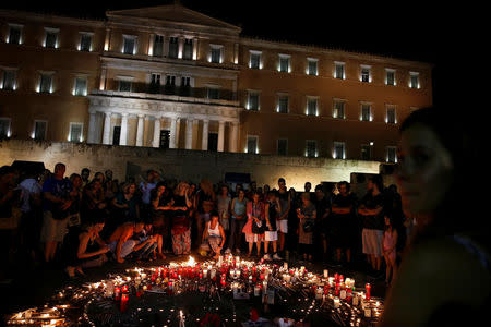 People light candles outside the parliament building to commemorate the victims of a wildfire that left at least 91 dead, in Athens, Greece, July 30, 2018. REUTERS/Costas Baltas