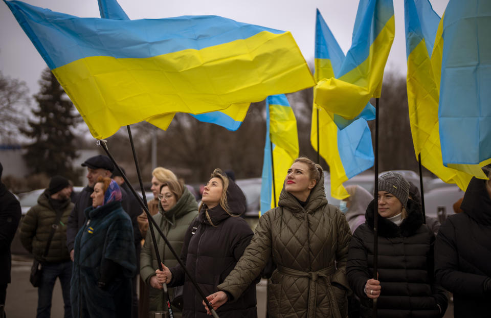 Women hold Ukrainian flags as they gather to celebrate a Day of Unity in Odessa, Ukraine, Wednesday, Feb. 16, 2022. As Western officials warned a Russian invasion could happen as early as today, the Ukrainian President Zelenskyy called for a Day of Unity, with Ukrainians encouraged to raise Ukrainian flags across the country. (AP Photo/Emilio Morenatti)