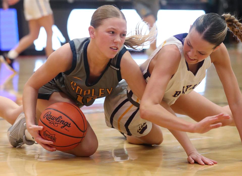 Copley's Emily Kerekes battles Bryan's Ella Rau for the ball in a Division II regional final March 8 in Mansfield.