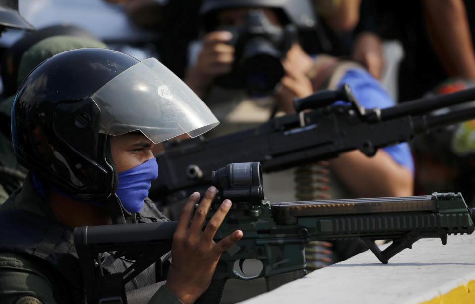 Soldados rebeldes armados cubren un paso elevado fuera de la base aérea militar de La Carlota, donde se encuentran las tropas leales a Nicolás Maduro en Caracas, Venezuela, el martes 30 de abril de 2019. (AP Foto / Fernando Llano)