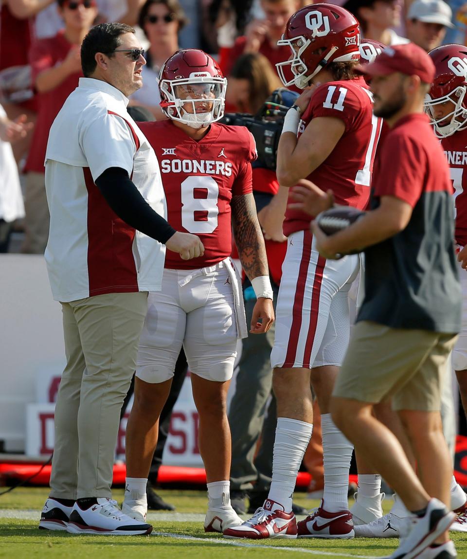 Offensive coordinator Jeff Lebby talks with Oklahoma Sooners quarterbacks Dillon Gabriel (8) and Davis Beville (11) before the Red River Showdown.
