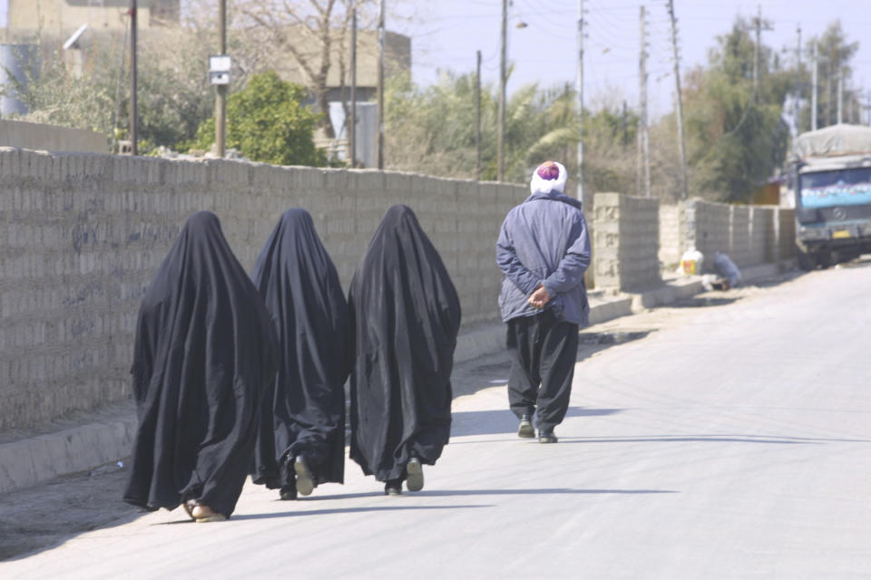 This February 2003 photo provided by photographer Murat Düzyol shows three women walking behind a man in Erbil, Iraq. A version of this original image was manipulated to digitally add chains on the women's ankles, with a caption erroneously claiming it was made in Afghanistan after the Taliban took control of the country in August 2021. (Murat Düzyol via AP)