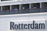 Passengers look out from Carnaval's Holland America cruise ship Rotterdam as it arrives at Port Everglades during the new coronavirus pandemic, Thursday, April 2, 2020, in Fort Lauderdale, Fla. Those passengers that are fit for travel in accordance with guidelines from the U.S. Centers for Disease Control will be permitted to disembark. (AP Photo/Lynne Sladky)