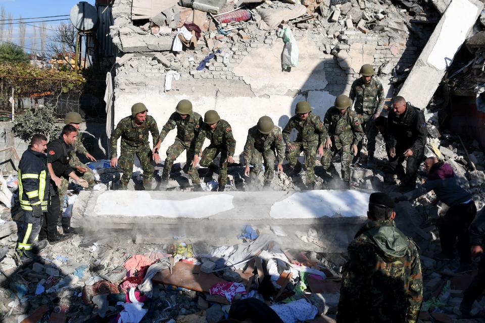 Emergency workers clear debris at a damaged building in Thumane, 34 kilometres (about 20 miles) northwest of capital Tirana, after an earthquake hit Albania, on November 26, 2019. Photo: Gent Shkullaku/AFP via Getty Images)