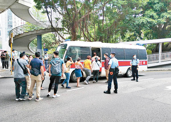 中環：被捕女傭由警員押走。