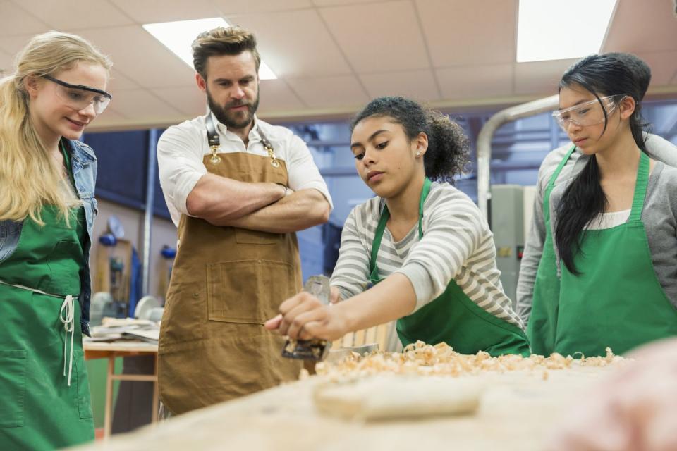 carpentry teacher and students working in workshop