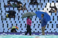 Reserve umpire Shaun George of South Africa, left, chats with head groundsman, as toss is officially been delayed due to rain for the first T20 cricket match between South Africa and West Indies, at Centurion Park, South Africa, in Pretoria, South Africa, Saturday, March 25, 2023. (AP Photo/Themba Hadebe)