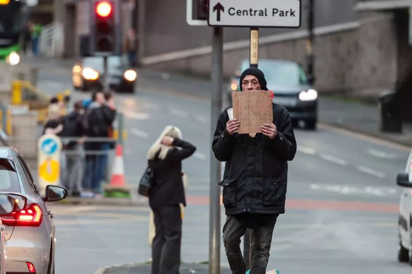 A man on the Bury New Road and Trinity Way junction traffic lights appealing for help -Credit:Manchester Evening News