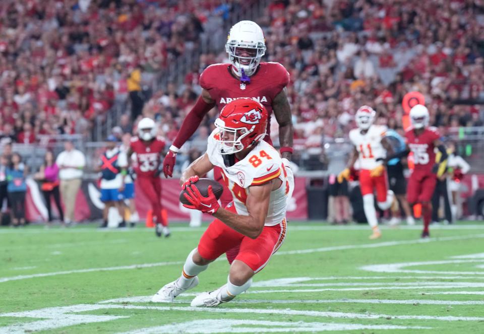 Kansas City Chiefs wide receiver Justin Watson (84) catches a touchdown pass against Arizona Cardinals linebacker Isaiah Simmons (9) during the first half at State Farm Stadium in Glendale on Aug. 19, 2023.