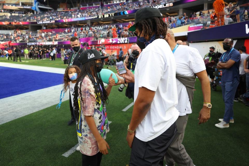 Jay Z shows Blue Ivy the photos he took of her during Super Bowl (Getty Images)