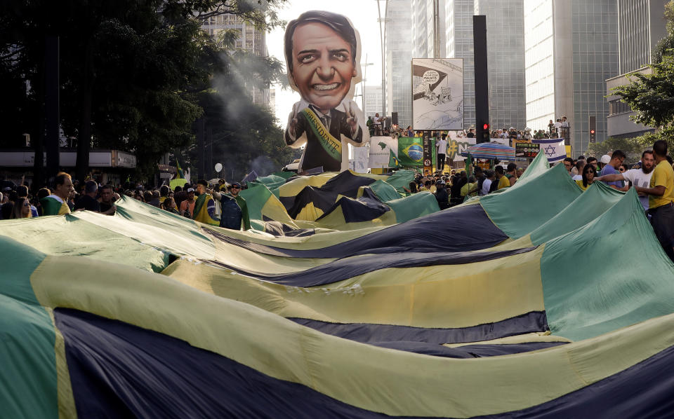 Supporters of Brazil's President Jair Bolsonaro feature a large, inflatable doll in his image as they demonstrate along Paulista Avenue in Sao Paulo, Brazil, Sunday, May 26, 2019. The pro-Bolsonaro rally follows anti-government protests against education budget cuts as the president also battles an uncooperative Congress, a family corruption scandal and falling approval ratings after five months in office. (AP Photo/Andre Penner)