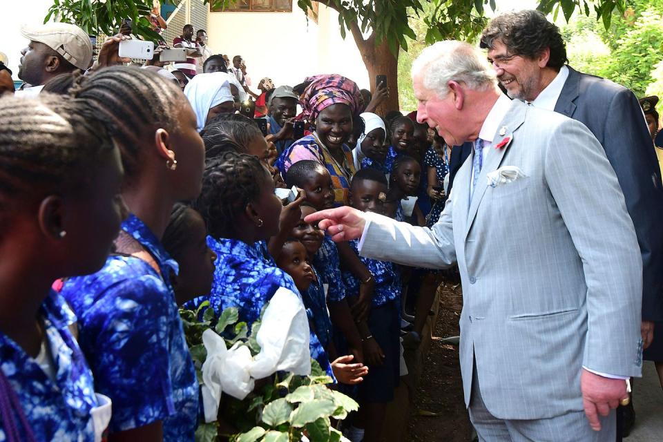 <p>Prince Charles speaks with children in the crowd as he arrives at a Malaria research center. </p>