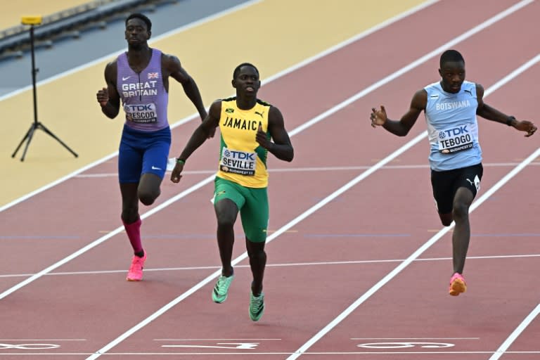 Le sprinter jamaïcain Oblique Seville passe la ligne d'arrivée de la demi-finale du 100m aux Championnats du monde d'athlétisme, à Budapest en Hongrie, le 20 août 2023 (Attila KISBENEDEK)