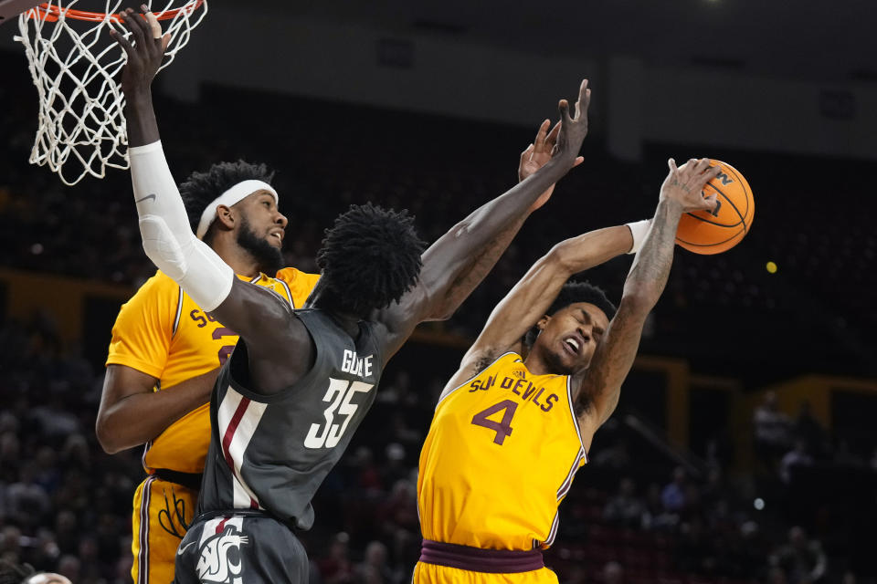 Arizona State guard Desmond Cambridge Jr. (4) grabs a rebound behind Washington State forward Mouhamed Gueye (35) and Arizona State forward Warren Washington, left, during the first half of an NCAA college basketball game in Tempe, Ariz., Thursday, Jan. 5, 2023. (AP Photo/Ross D. Franklin)