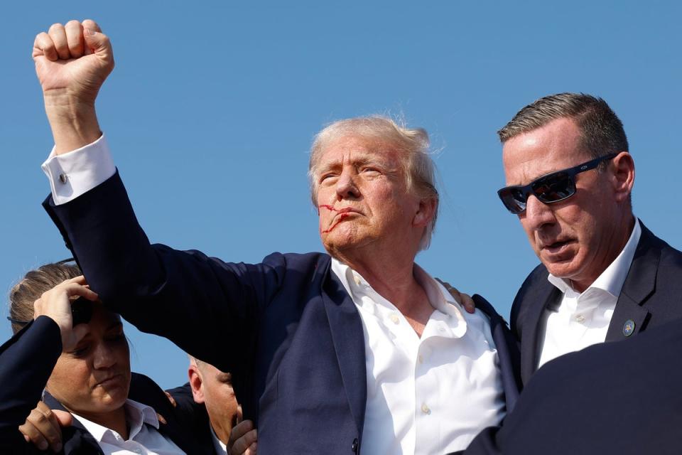 Donald Trump clenches his fist as he is led off the stage during a rally in Butler, Pennsylvania, on July 13, 2024. The FBI has released new photos of the rifle used in the shooting. (Getty Images)