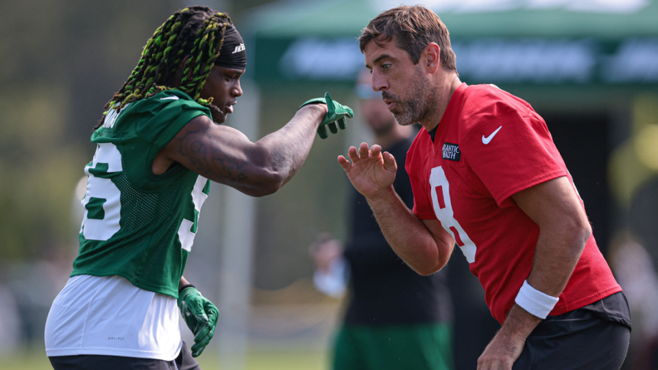 Quincy Williams and Aaron Rodgers celebrate with a handshake during training with the New York Jets