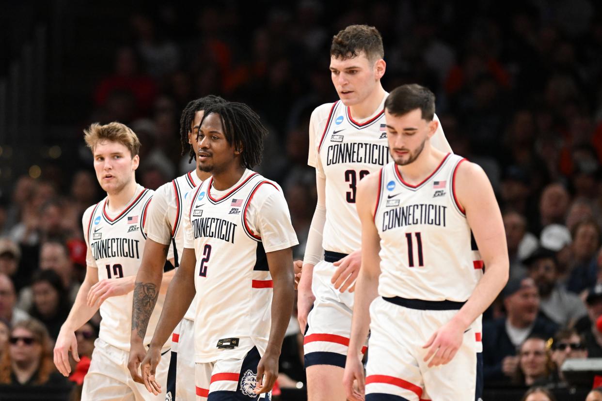 Connecticut Huskies guard Cam Spencer (12) and guard Tristen Newton (2), forward Alex Karaban (11) react against the San Diego State Aztecs in the semifinals of the East Regional of the 2024 NCAA Tournament at TD Garden in Boston on March 28, 2024.