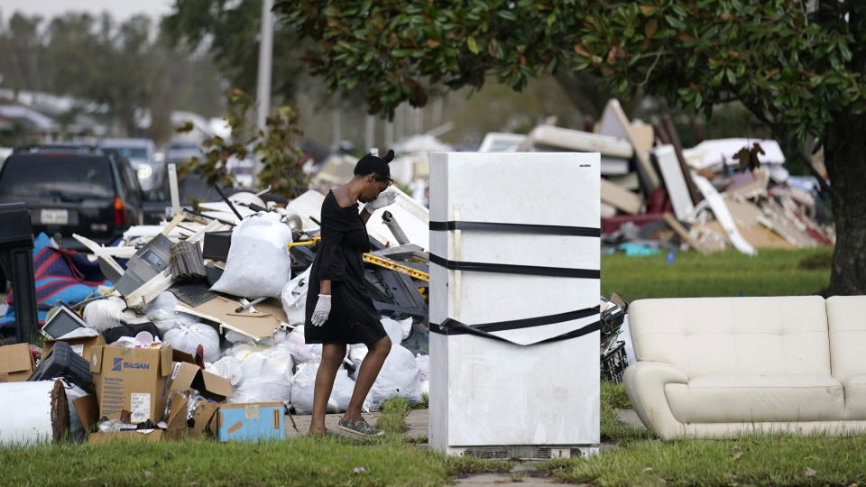 Lori Butler wipes her brow as she moves debris she is gutting from her home that was flooded, in the aftermath of Hurricane Ida in LaPlace, La., Tuesday, Sept. 7, 2021. (AP Photo/Gerald Herbert)