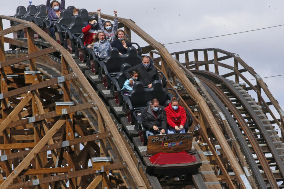 People ride the Roller Coaster at Lagoon Amusement Park Saturday, May 23, 2020, in Farmington, Utah. After a season break that was extended for months by COVID-19 restrictions, Utah's amusement park, Lagoon, reopened for business just in time for the Memorial Day weekend. Lagoon officials said a new reservation system is in place to help manage social distancing and avoid crowding at the park entrance, and capacity will be limited to about 15% of its usual maximum volume. (AP Photo/Rick Bowmer)