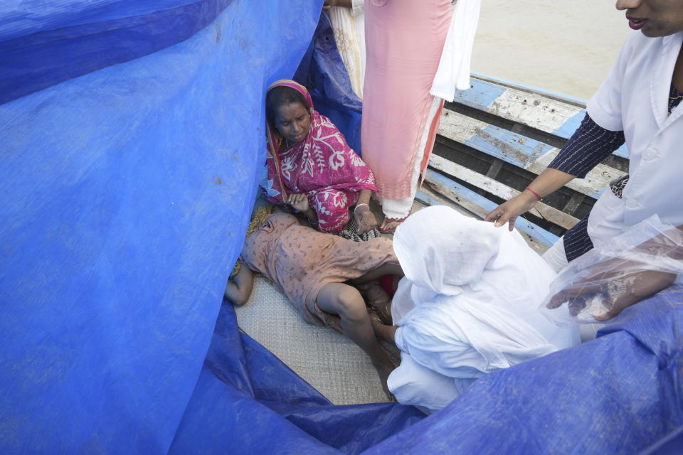 Diluwara Begum, comadrona, ayuda a Jahanara Khatoon, de 25 años, a dar a luz en el río Brahmaputra, en el estado nororiental indio de Assam, el miércoles 3 de julio de 2024. (AP Foto/Anupam Nath)