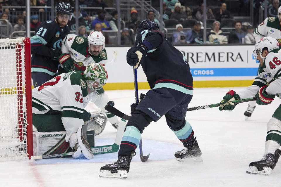 Seattle Kraken right wing Jordan Eberle (7) has his shot on goal blocked by Minnesota Wild goaltender Filip Gustavsson (32) and defenseman Jared Spurgeon (46) during the first period of an NHL hockey game, Sunday, Dec. 10, 2023, in Seattle. (AP Photo/John Froschauer)