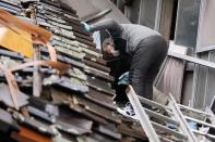 A man searches a collapsed house caused by powerful earthquake in Suzu, Ishikawa Prefecture Wednesday, Jan. 3, 2024. A series of powerful earthquakes hit western Japan, damaging buildings, vehicles and boats, with officials warning people in some areas on Tuesday to stay away from their homes because of a risk of more strong quakes. (AP Photo/Hiro Komae)