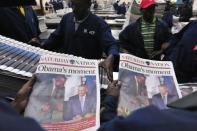 Workers at Kenya's leading Nation newspaper sort copies carrying headlines on US President Barack Obama (R) and his Kenyan counterpart Uhuru Kenyatta, on July 25, 2015