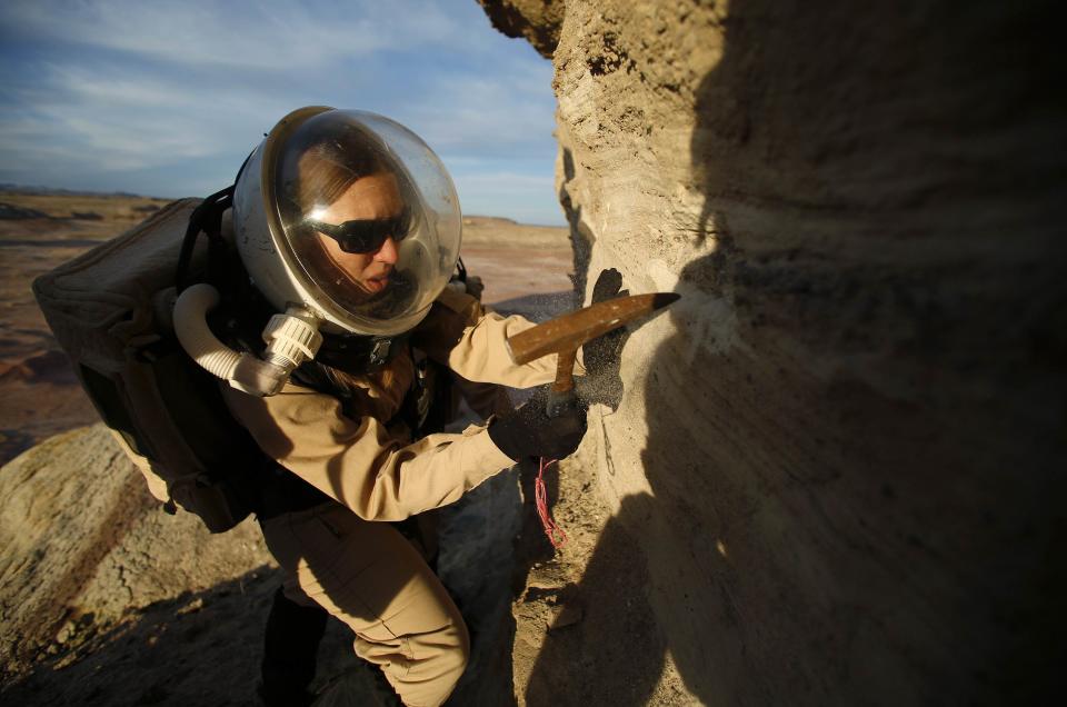 Melissa Battler, a geologist and commander of Crew 125 EuroMoonMars B mission, collects geologic samples for study at the Mars Desert Research Station (MDRS) in the Utah desert March 2, 2013. The MDRS aims to investigate the feasibility of a human exploration of Mars and uses the Utah desert's Mars-like terrain to simulate working conditions on the red planet. Scientists, students and enthusiasts work together developing field tactics and studying the terrain. All outdoor exploration is done wearing simulated spacesuits and carrying air supply packs and crews live together in a small communication base with limited amounts of electricity, food, oxygen and water. Everything needed to survive must be produced, fixed and replaced on site. Picture taken March 2, 2013. REUTERS/Jim Urquhart