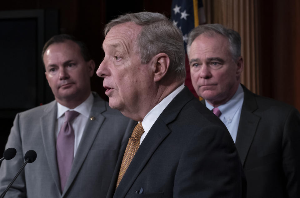 Sen. Dick Durbin, D-Ill., center, flanked by Sen. Mike Lee, R-Utah, left, and Sen. Tim Kaine, D-Va., speaks to reporters just after the Senate advanced a bipartisan resolution asserting that President Donald Trump must seek approval from Congress before engaging in further military action against Iran, at the Capitol in Washington, Wednesday, Feb. 12, 2020. (AP Photo/J. Scott Applewhite)