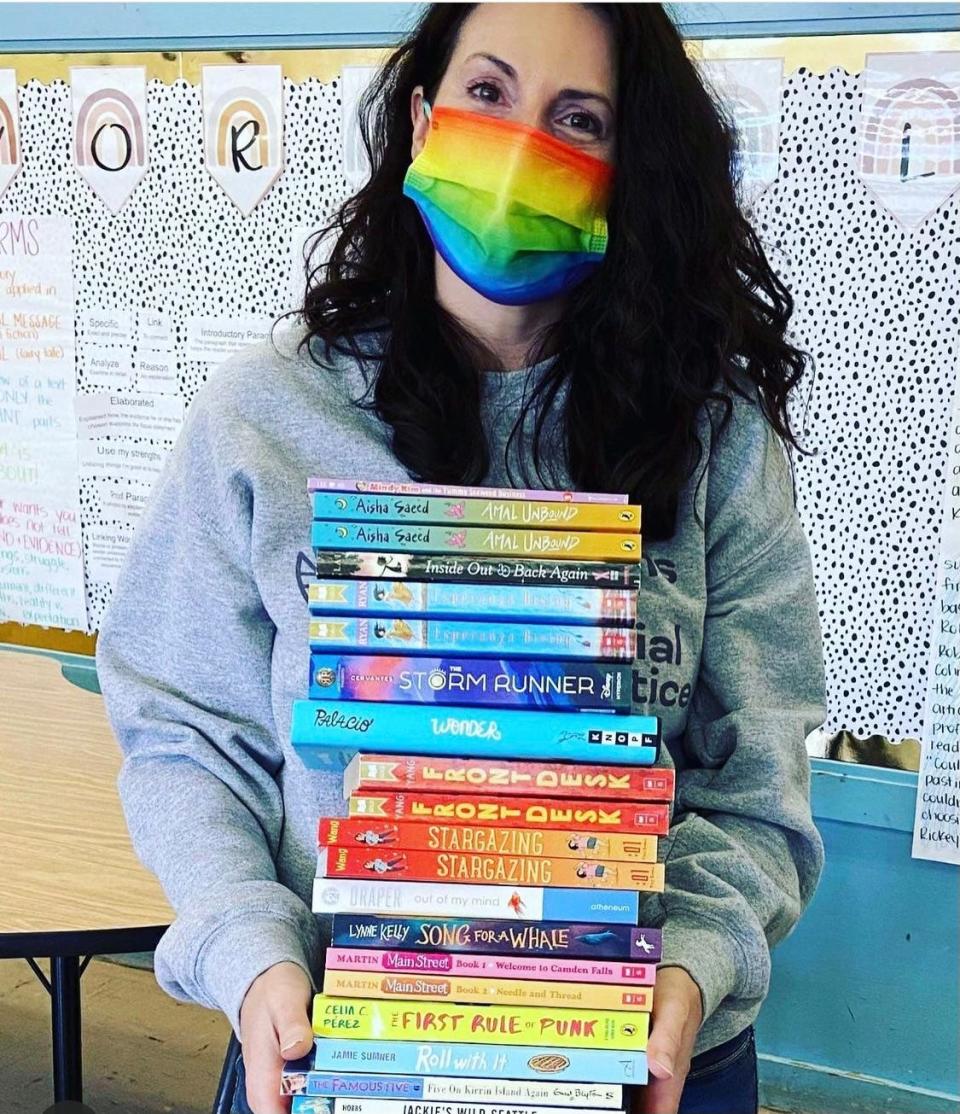 Taylor Lyons, one of the founders of the parent advocacy group Moms for Social Justice in Chattanooga, Tenn., is pictured with a stack of books collected to donate to Hamilton County Schools.