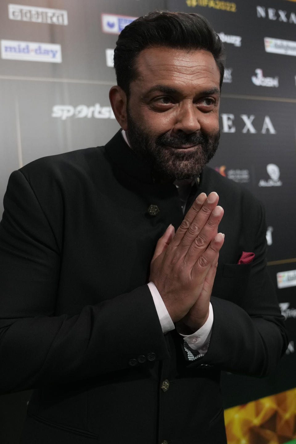 Indian actor Bobby Deol greets photographers on the green carpet ahead of the 22nd International Indian Film Academy (IIFA) awards in Abu Dhabi, United Arab Emirates, Friday, June 3, 2021. (AP Photo/Kamran Jebreili)