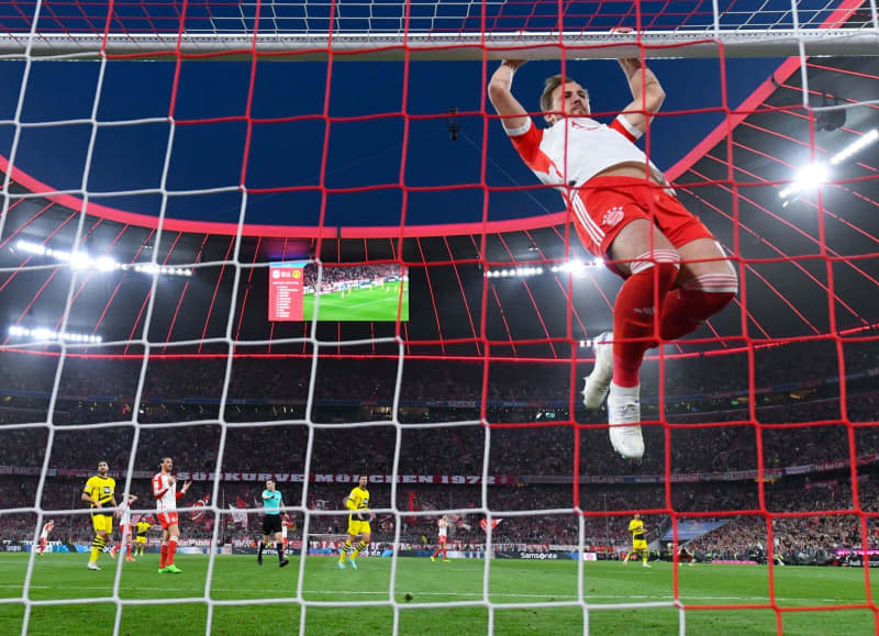Munich's Harry Kane jumps into the goal of Dortmund during German Bundesliga soccer match between Bayern Munich and Borussia Dortmund at the Allianz Arena. Sven Hoppe/dpa