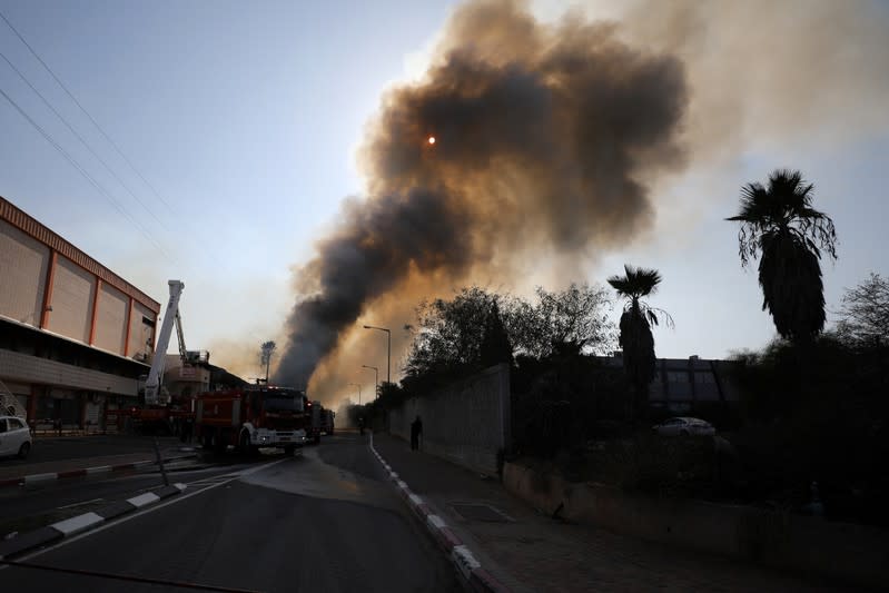 A general view shows Israeli firefighters as they work to extinguish a fire in a factory in Sderot, southern Israel