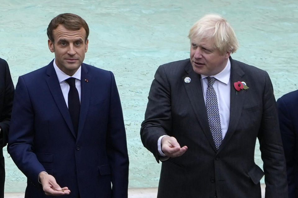 French President Emmanuel Macron, left, and British Prime Minister Boris Johnson prepare to throw a coin in the water at the Trevi Fountain during an event for the G20 summit in Rome, Sunday, Oct. 31, 2021. The two-day Group of 20 summit concludes on Sunday, the first in-person gathering of leaders of the world's biggest economies since the COVID-19 pandemic started. (AP Photo/Gregorio Borgia)