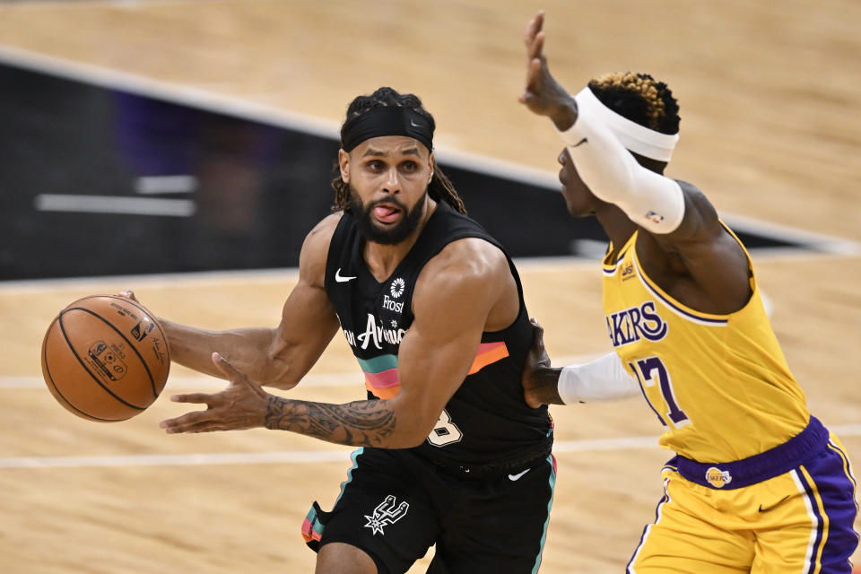 San Antonio Spurs' Patty Mills, left, drives against Los Angeles Lakers' Dennis Schroeder during the first half of an NBA basketball game Friday, Jan. 1, 2021, in San Antonio. (AP Photo/Darren Abate)