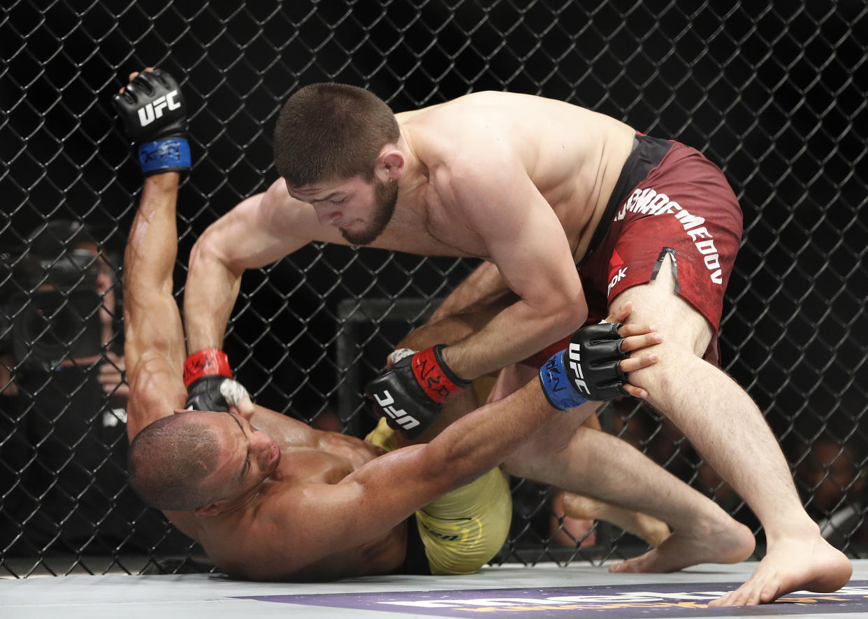 Khabib Nurmagomedov hits Edson Barboza during a lightweight mixed martial arts bout at UFC 219, Saturday, Dec. 30, 2017, in Las Vegas. (AP Photo/John Locher)