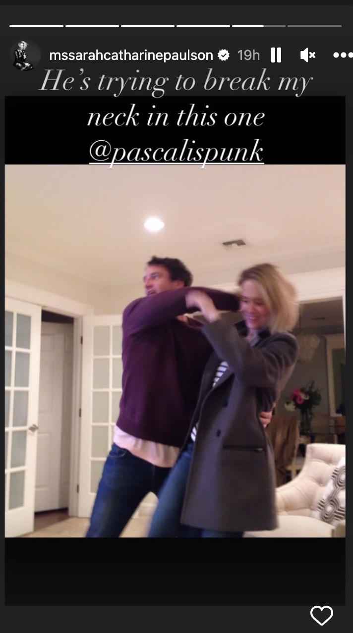A screenshot from Sarah's IG story of Pedro and Sarah pretend fighting, with caption "He's trying to break my neck in this one"
