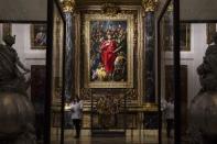 A journalist stands underneath Spanish Renaissance painter El Greco's "El Expolio", or "The Disrobing of Christ", painting during a ceremony marking its return following restoration to the sacristy of the Cathedral of Toledo, January 22, 2014. REUTERS/Paul Hanna